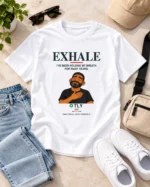 White Exhale Inner Strength t-shirt laid flat with jeans and accessories